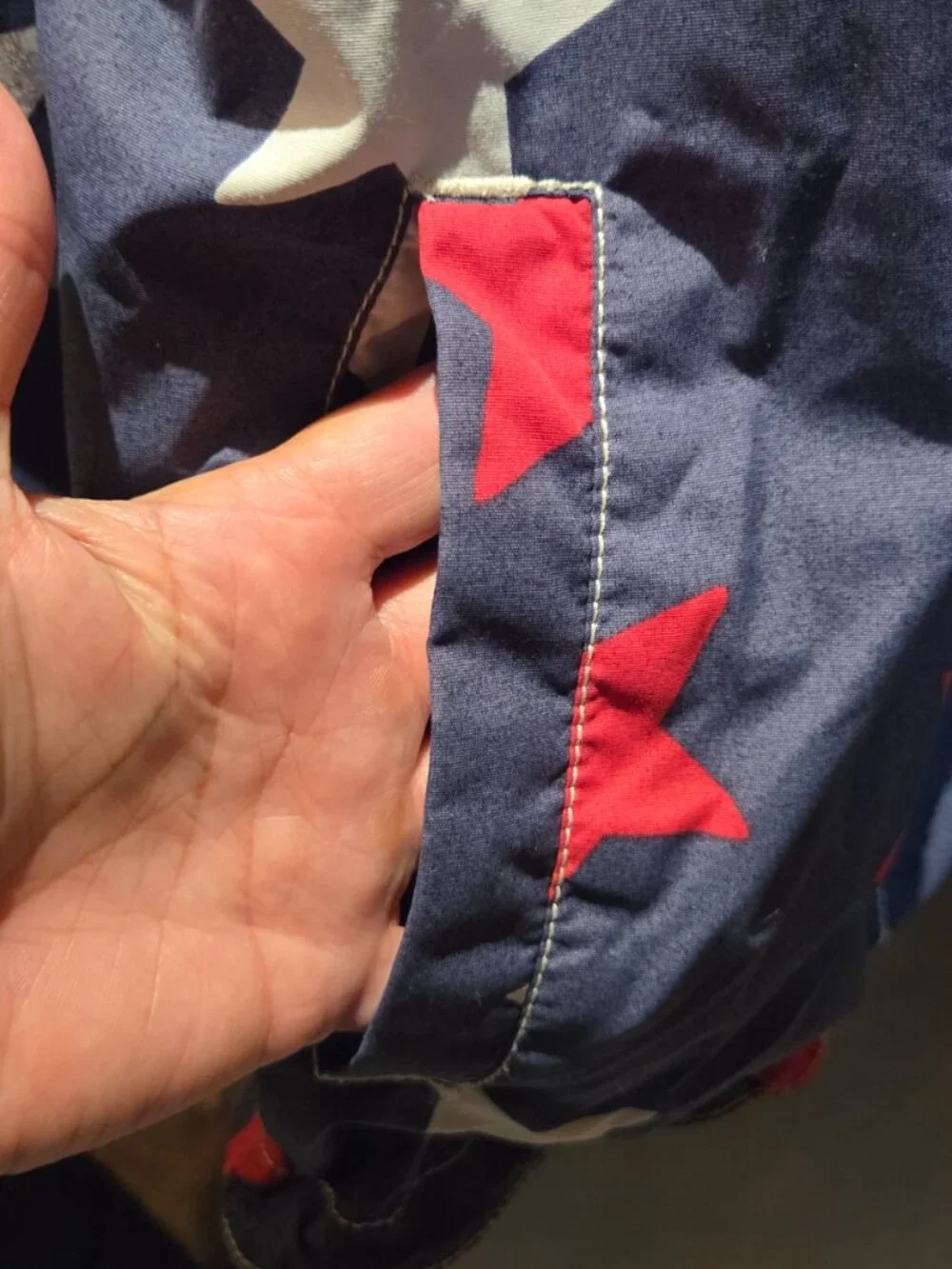rain jacket features a navy blue background covered in a bold red and white star